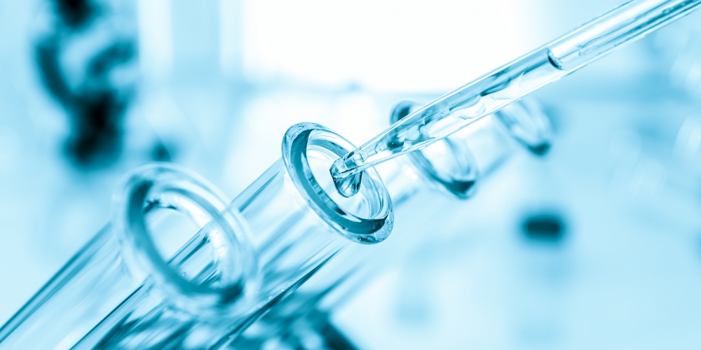 Pipette adding fluid to one of several test tubes .medical glassware